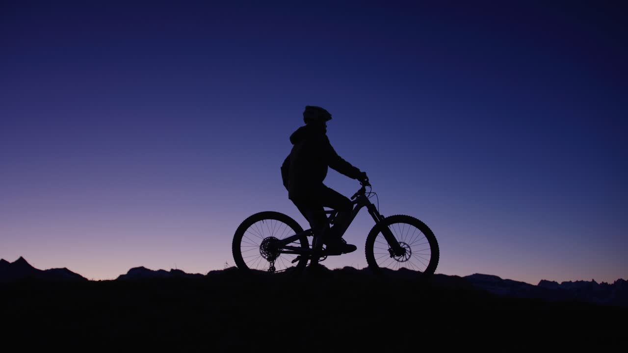 자전거 타는 사람이 새벽 능선 위에 서 있다