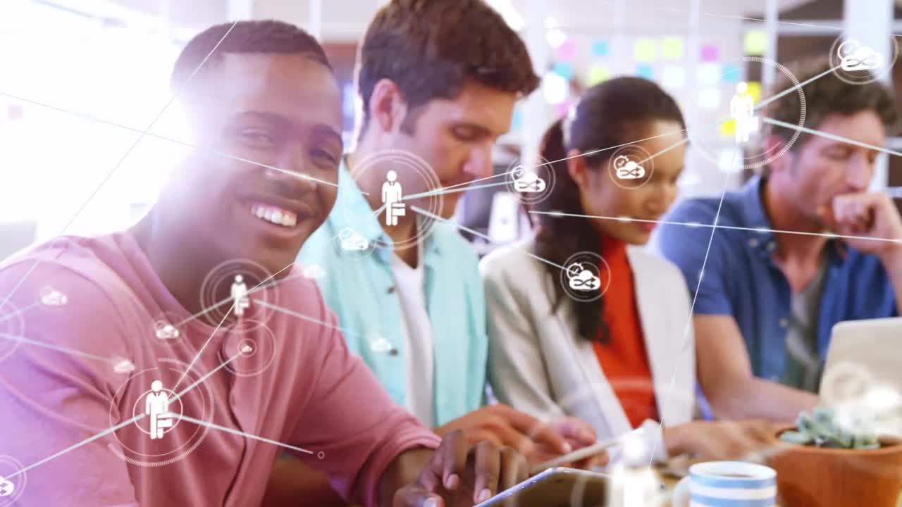 animación de iconos digitales sobre el retrato de un hombre afroamericano usando una tableta digital en la oficina