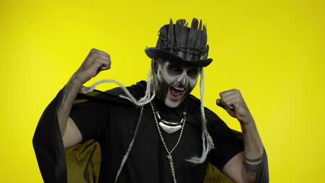 happy creepy man with skeleton makeup celebrating win, emotionally rejoicing in victory success