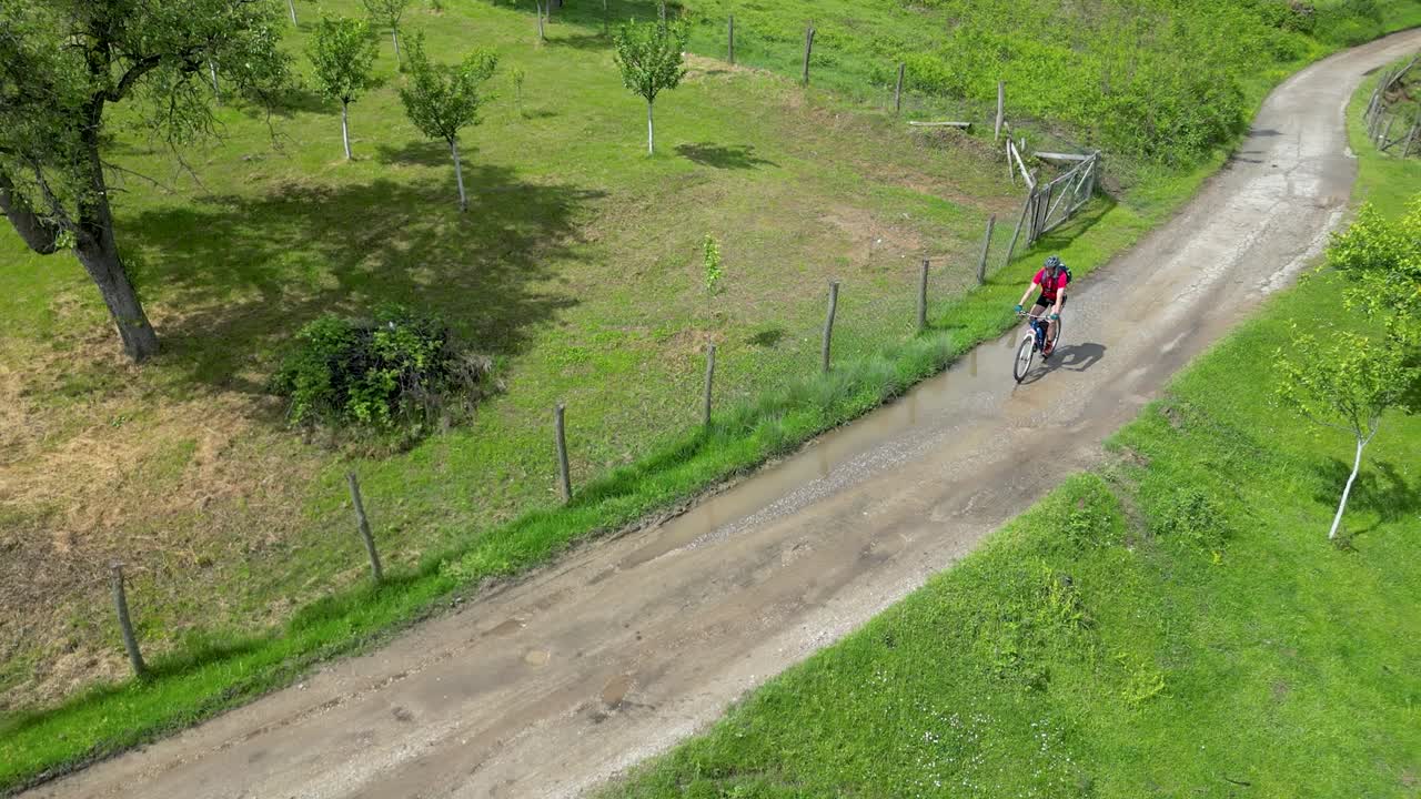 Riding a bicycle in countryside. Drone footage on summer day