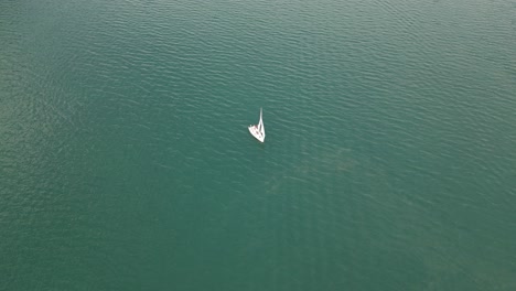 Lonely-yacht-sailing-in-peaceful-waves-of-Walensee-lake-in-Switzerland,drone-shot