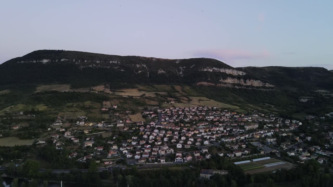 Aerial view of scenic romantic french city of a small historic town of Millau, France. Drone flying along beautiful french city nested among the hills and Tarn river flowing through the city