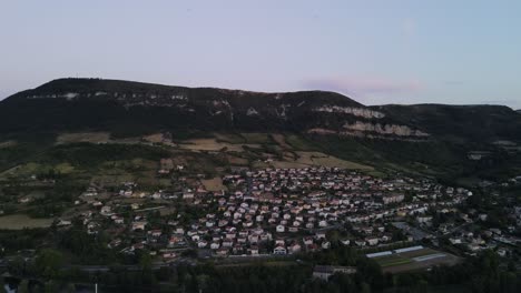 aerial view of scenic romantic french city of a small historic town of millau, france. drone flying along beautiful french city nested among the hills and tarn river flowing through the city