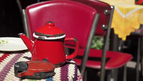 una tetera roja de época en un café al aire libre