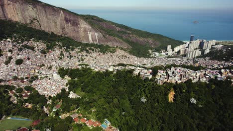 Aerial-view-tilting-over-a-dense,-ghetto-community,-Favela-da-Rocinha,-in-sunny-Rio,-Brazil