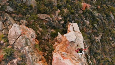 aerial view captures a young caucasian man on a rocky outcrop, with copy space