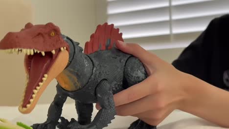 boy playing with a prehistoric dinosaur action figure toy in bedroom