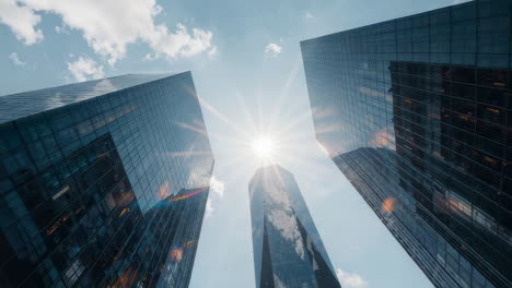 modern skyscrapers with sunburst in blue sky