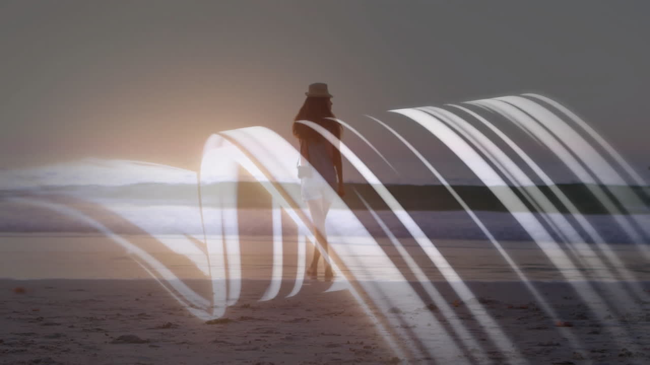 Walking on beach, woman surrounded by animation of abstract light trails at sunset