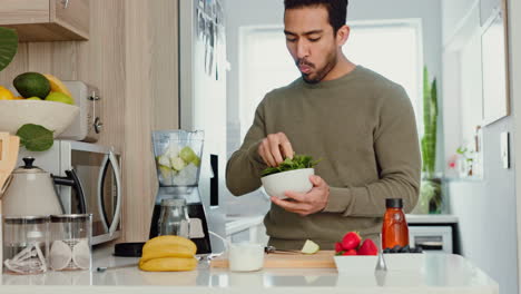 Man-makes-a-healthy-smoothie-in-kitchen-with-fruit