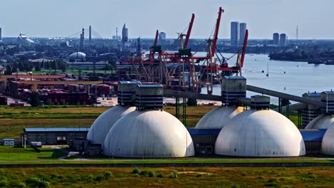 dome-shaped fertilizer storage containers at the riga, latvia baltic sea port terminal - sliding aerial reveal
