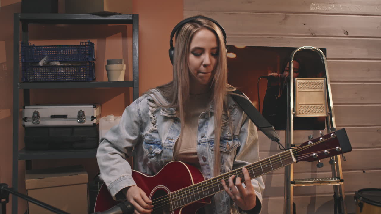 Blonde Female Guitarist In Headphones Playing Guitar