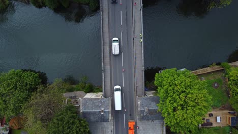 antena de arriba hacia abajo de tráfico dirigido por señales que se mueven en una sola fila a través de un antiguo puente de carretera victoriano en reparación, toldos en el puente