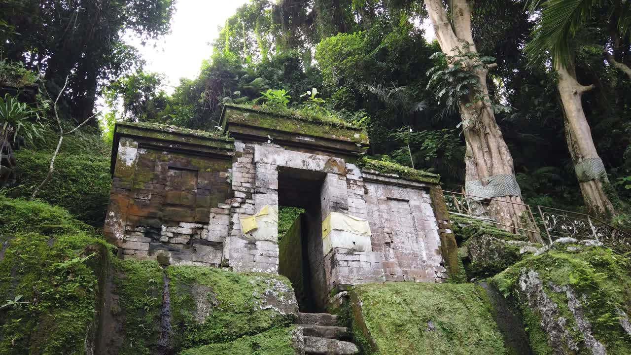 antiguo templo balinés goa garba, antiguas escaleras y puertas de piedra, musgo en un lugar arqueológico hindú, viajes y turismo bali, indonesia