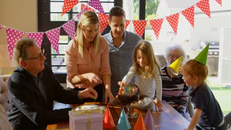 family decorating birthday cake in living room 4k