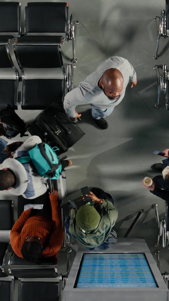 Overhead View of Passengers Waiting and Walking in Airport Terminal