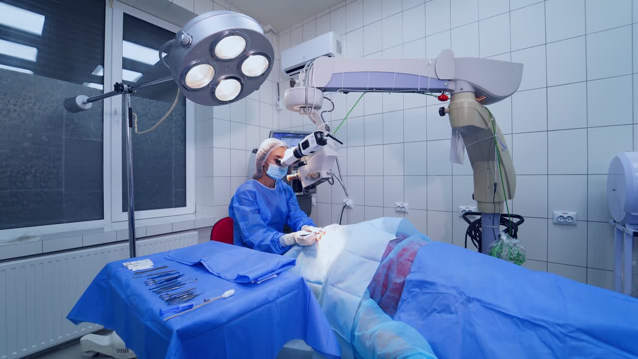 Patient under surgical microscope. Patient in room during ophthalmic surgery