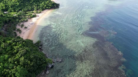 asombrosa vista aérea del arrecife costero bajo las transparentes olas del mar junto a la playa de arena blanca en catanduanes, filipinas