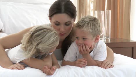 mother and children together in bed