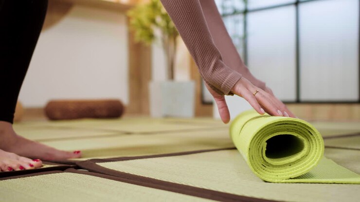 Persona che stende il tappetino da yoga sul pavimento