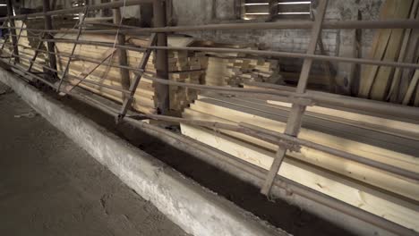 wooden beams stored in shed seperated with iron fence gimbal shot