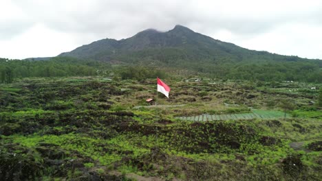 drone view of mount batur, an active volcano, with the indonesian flag in bali, indonesia