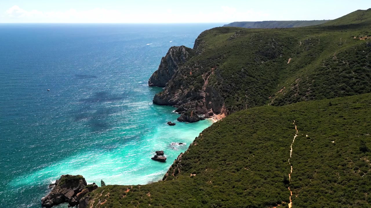 Portekiz, Praia do Ribeiro do Cavalo yakınlarındaki kıyı burnu ve turkuaz okyanus suyu. Yüksek kıyı şeridi manzaralarına sahip görkemli bir peyzaj.
