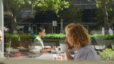 happy diverse couple drinking coffee and talking at a table in a cafe