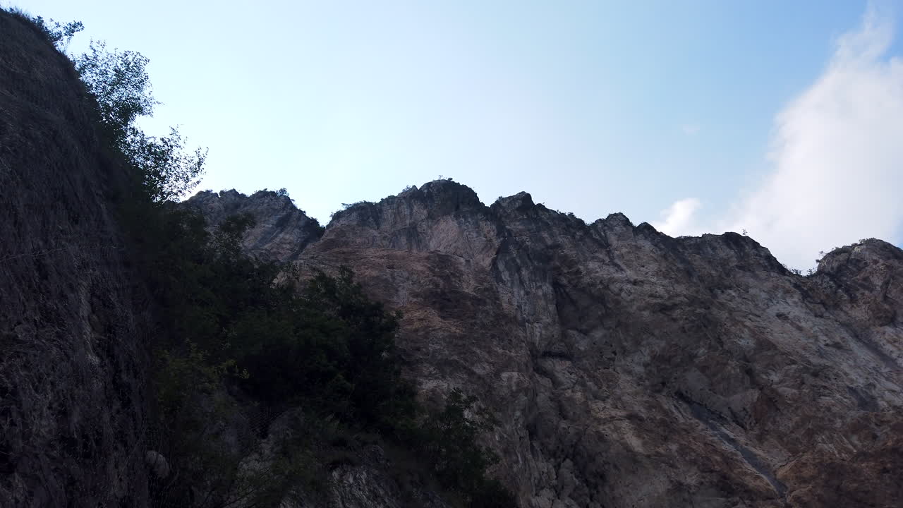 바람이 많이 부는 날 거칠고 절벽이 많은 산맥 위로 수직 패닝 샷