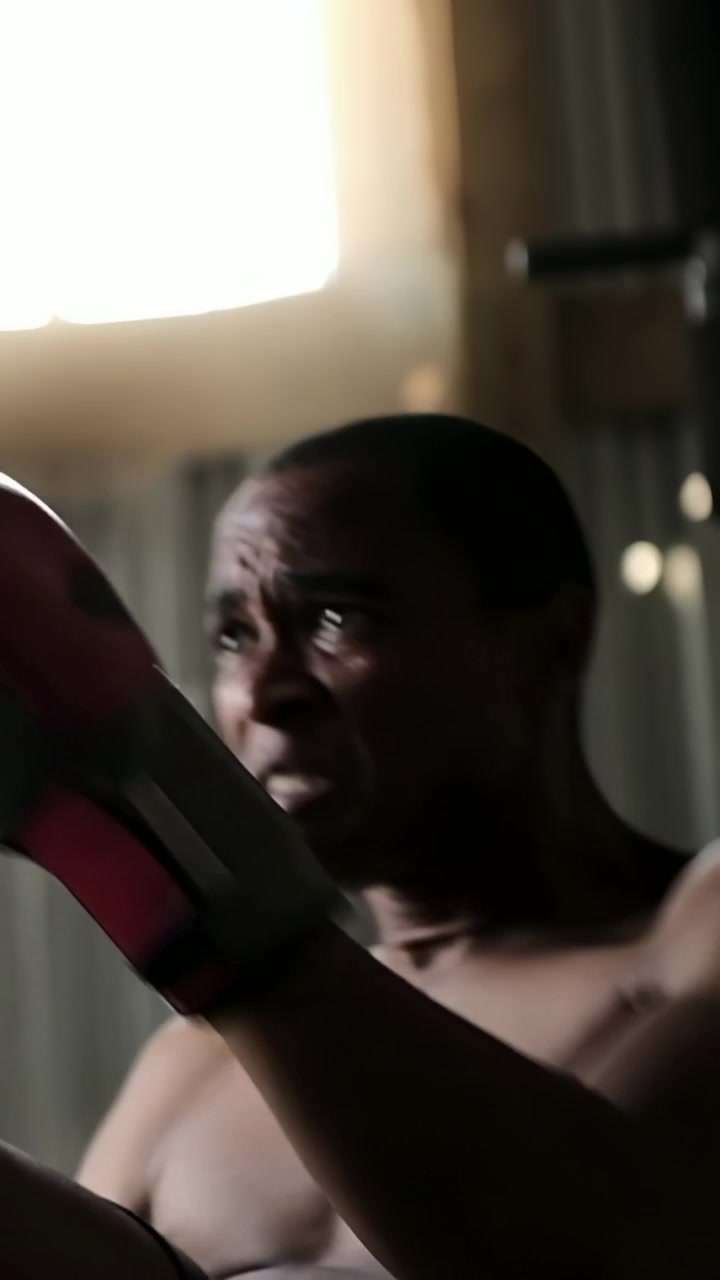 Vertical video: Preparing shirtless boxer raising red gloves, jabbing for training at warehouse gym