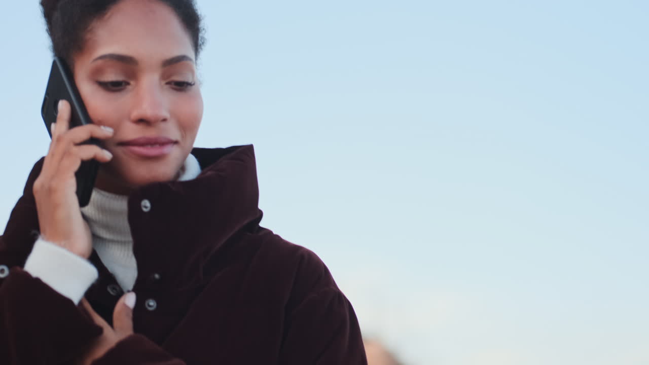 una chica afroamericana hablando por teléfono móvil.