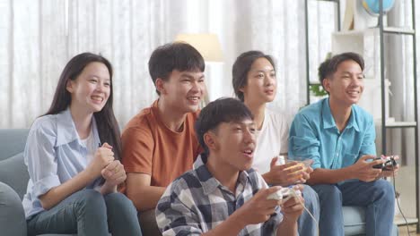 asian teenagers playing video games at home.