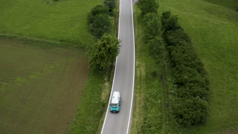 Luftaufnahme-Eines-Alten-Autos,-Das-Auf-Seinem-Europa-Roadtrip-Auf-Einer-Leeren-Straße-Fährt