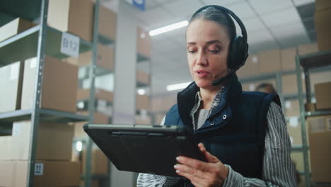 warehouse worker using tablet and headset