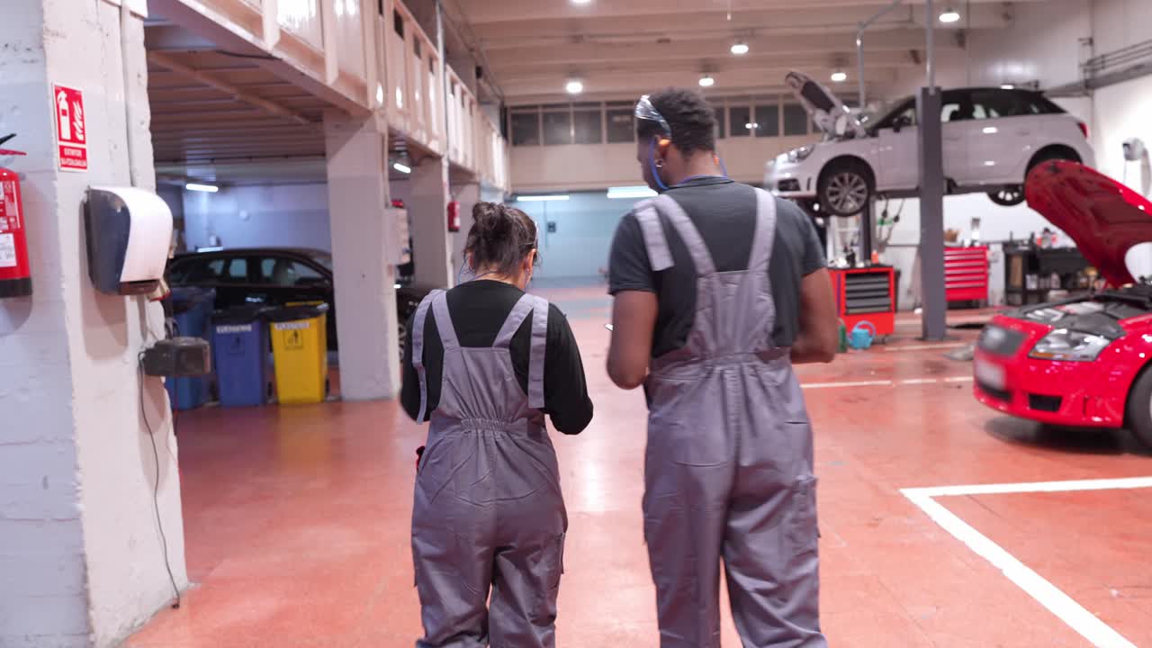 Autofficina con meccanici che controllano le auto