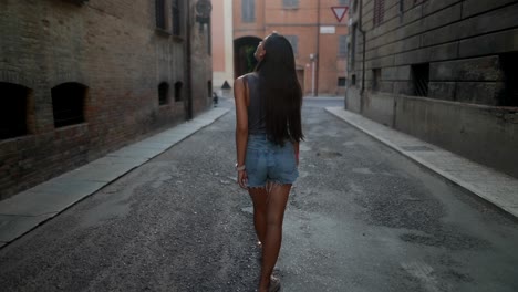 woman walking in a narrow city street