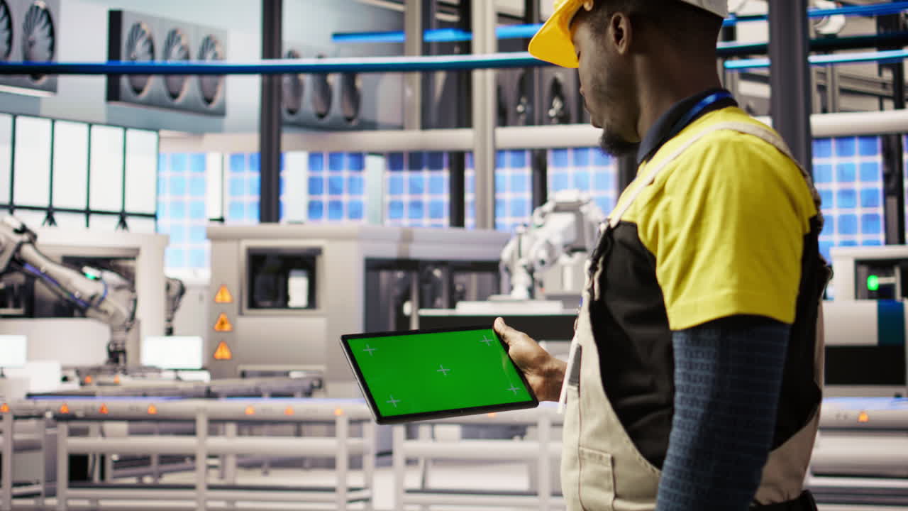 Vertical video Engineer in smart factory using mockup tablet to oversee robotic assembly lines