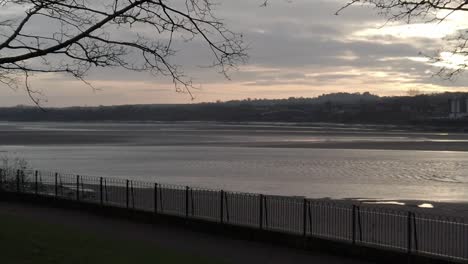 slow motion sunrise parallax across glowing urban waterfront regeneration mersey river promenade