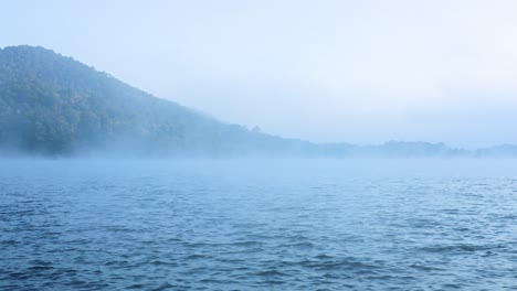 misty river with mountain in the background