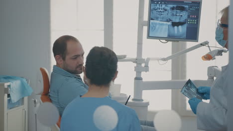 dentist and nurse explaining x ray scan to patient with toothache