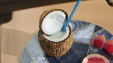 Kokoswassergetränk-Auf-Dem-Tisch-Im-Tropischen-Strandcafé,-Frisches,-Zartes-Kokosnussgetränk-Am-Tropischen-Strand