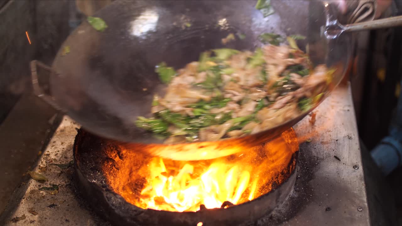 Chef preparing cooking Thai stir fried noodles with egg, vegetable, pork and soy sauce - Pad See Ew, One of the popular thai dishes, Slow motion 4K. Thai street food.