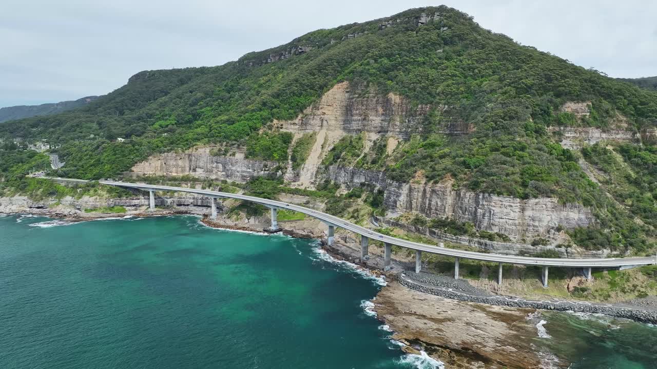 Overhead view of Sea Cliff Bridge hugging the cliffs above the Pacific Ocean in NSW Australia