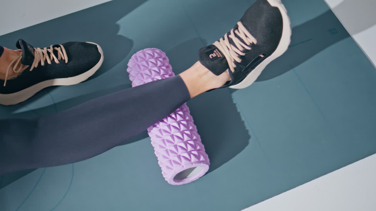 Closeup leg massaging foam roller training muscles in private gym at carpet