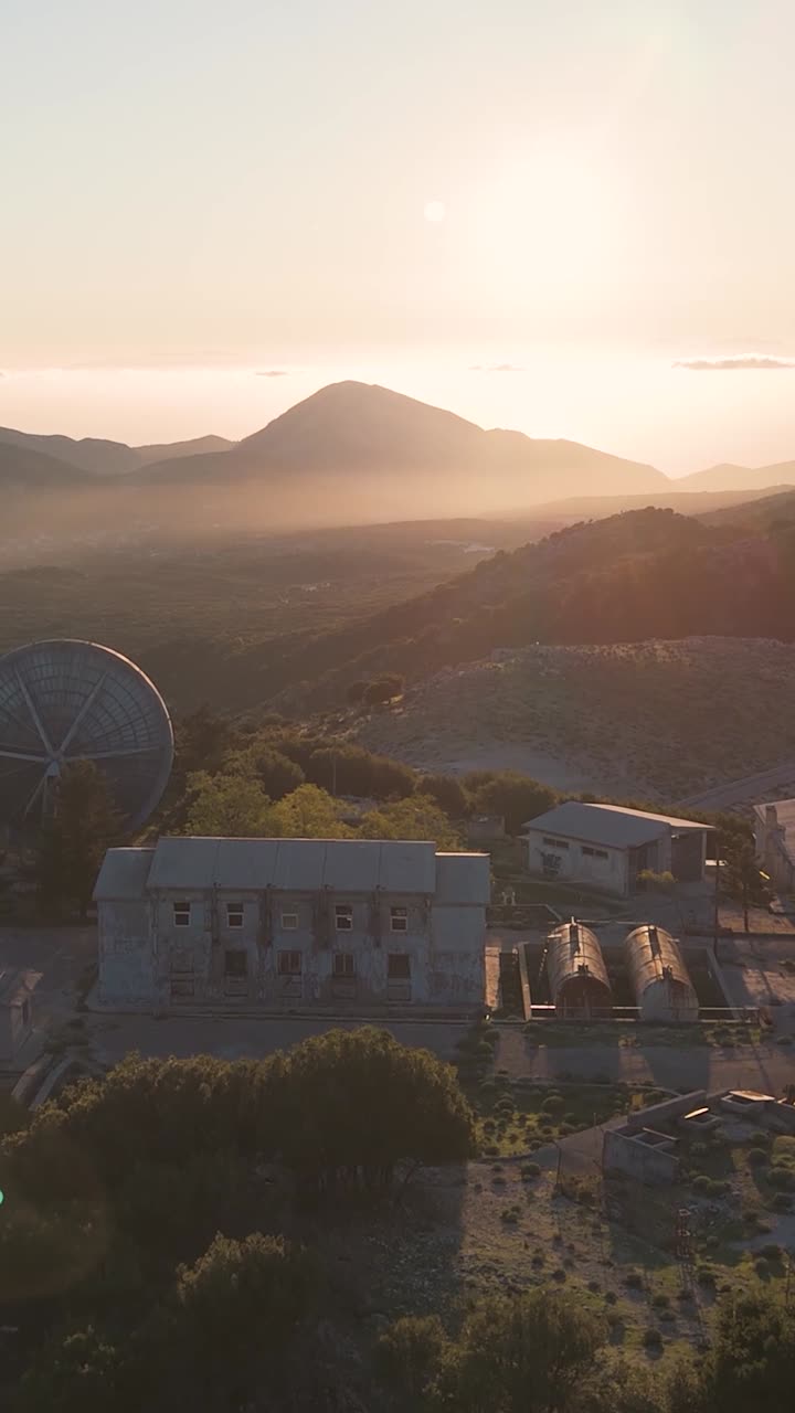 puesta de sol sobre la estación de satélite abandonada y el paisaje montañoso
