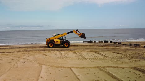 imágenes orbitales aéreas de drones de una excavadora trabajando en la playa de gorleston-on-sea, norfolk