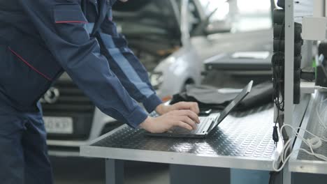 mechanic using a laptop for car diagnostics