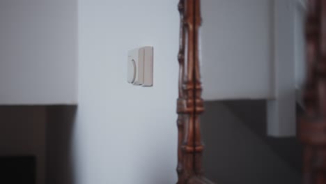 mujer ajustando el termostato para bajar la temperatura para ahorrar en facturas de energía durante la crisis del costo de la vida de cerca