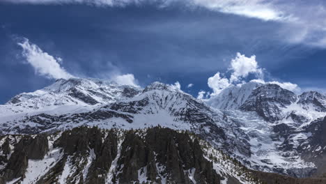 day timelapse overlooking the annapurna mountain range with clouds on a sunny day from manang, nepal