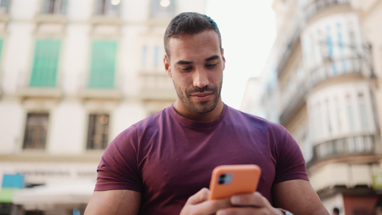 Young man texting on smartphone outdoors.